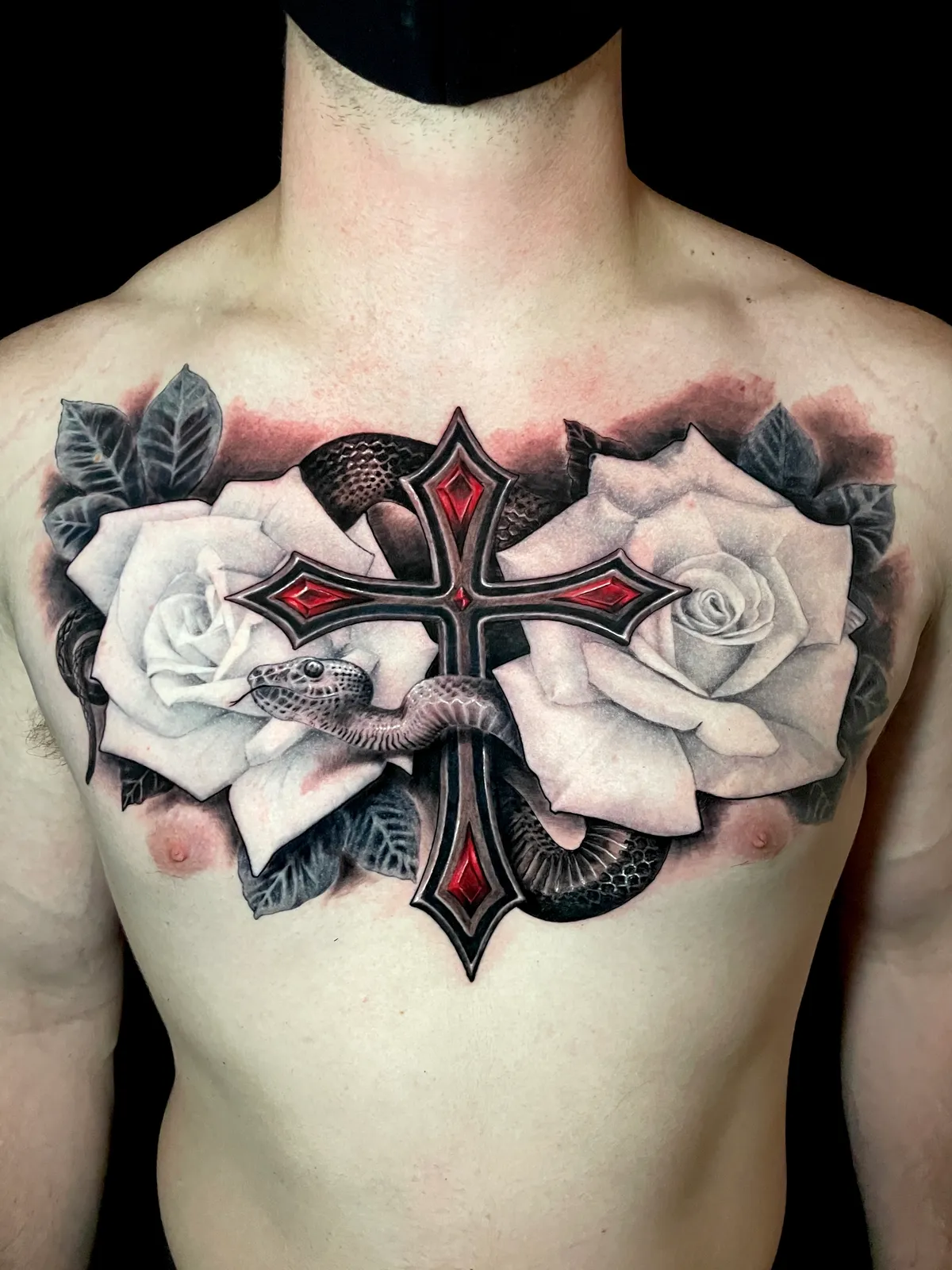 Black and grey realism ornate cross with roses and snake chest piece tattoo by Andras Tattoo