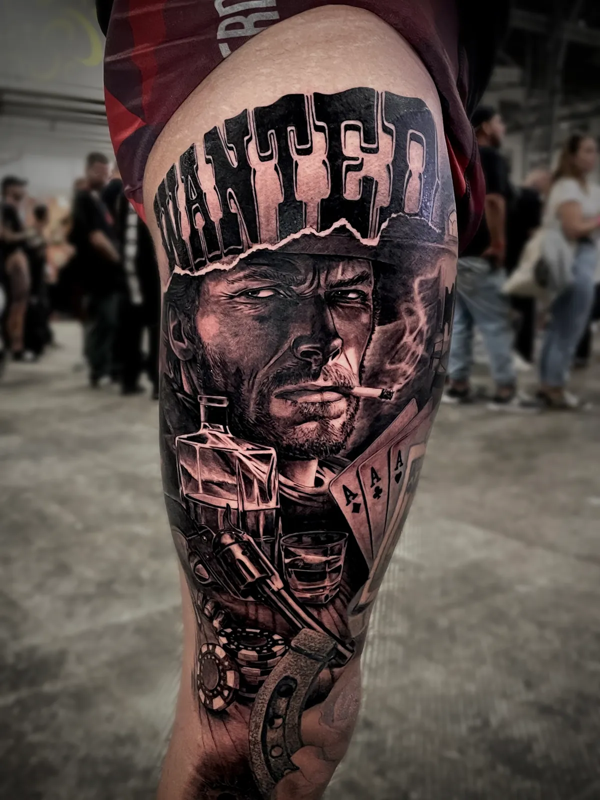 Black and grey realism Western cowboy portrait tattoo with wanted poster, playing cards and revolver on thigh by Paul Michael Andras